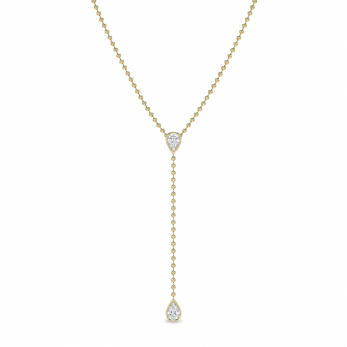 A delicate yellow gold Y-necklace featuring a pear-cut clear gemstone at the center and a longer drop chain ending in a teardrop-shaped clear gemstone, shown against a plain white background.